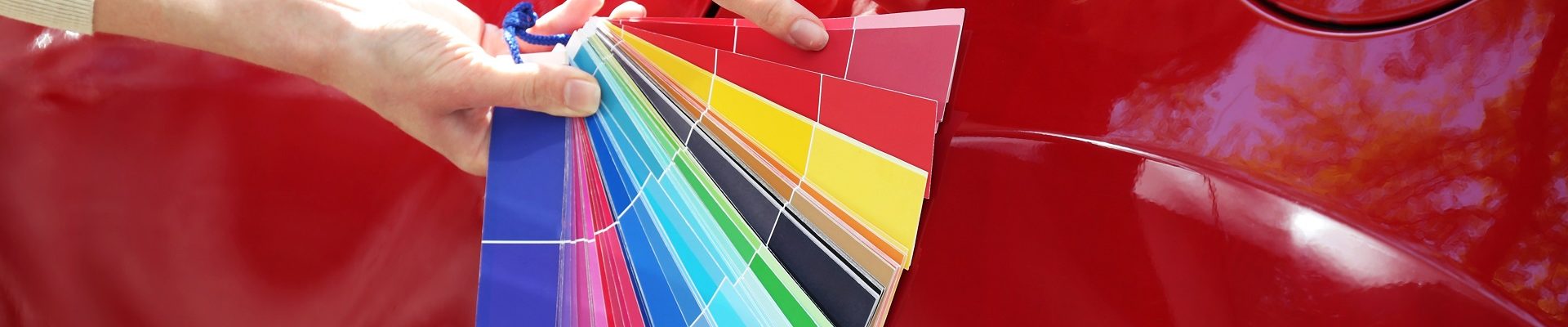 Female hands with paint samples choosing color for painting car, closeup